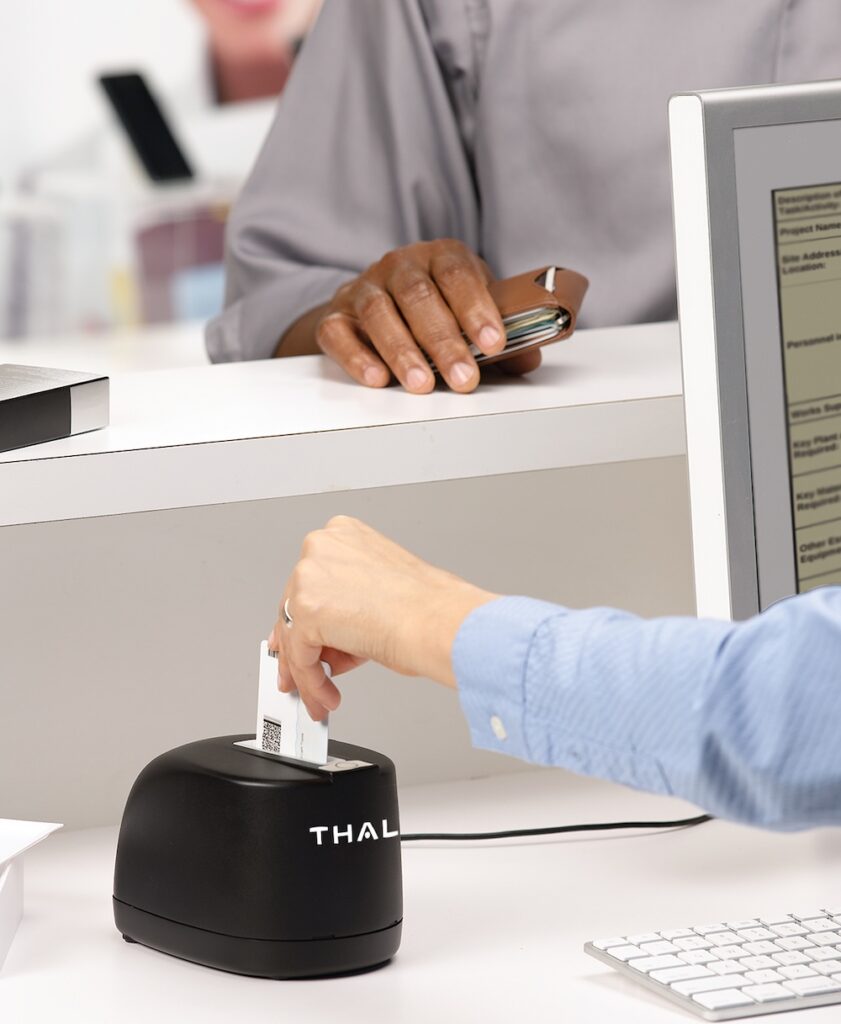 a Hand dropping an ID into a document authentication scanner